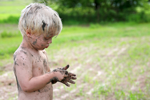 Cute Dirty Child Playing Outside in the Country