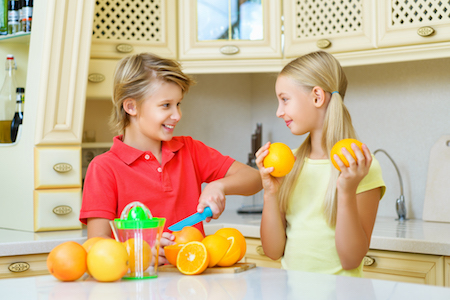 Funny teenagers with citrus. Boy and girl holding fruit oranges